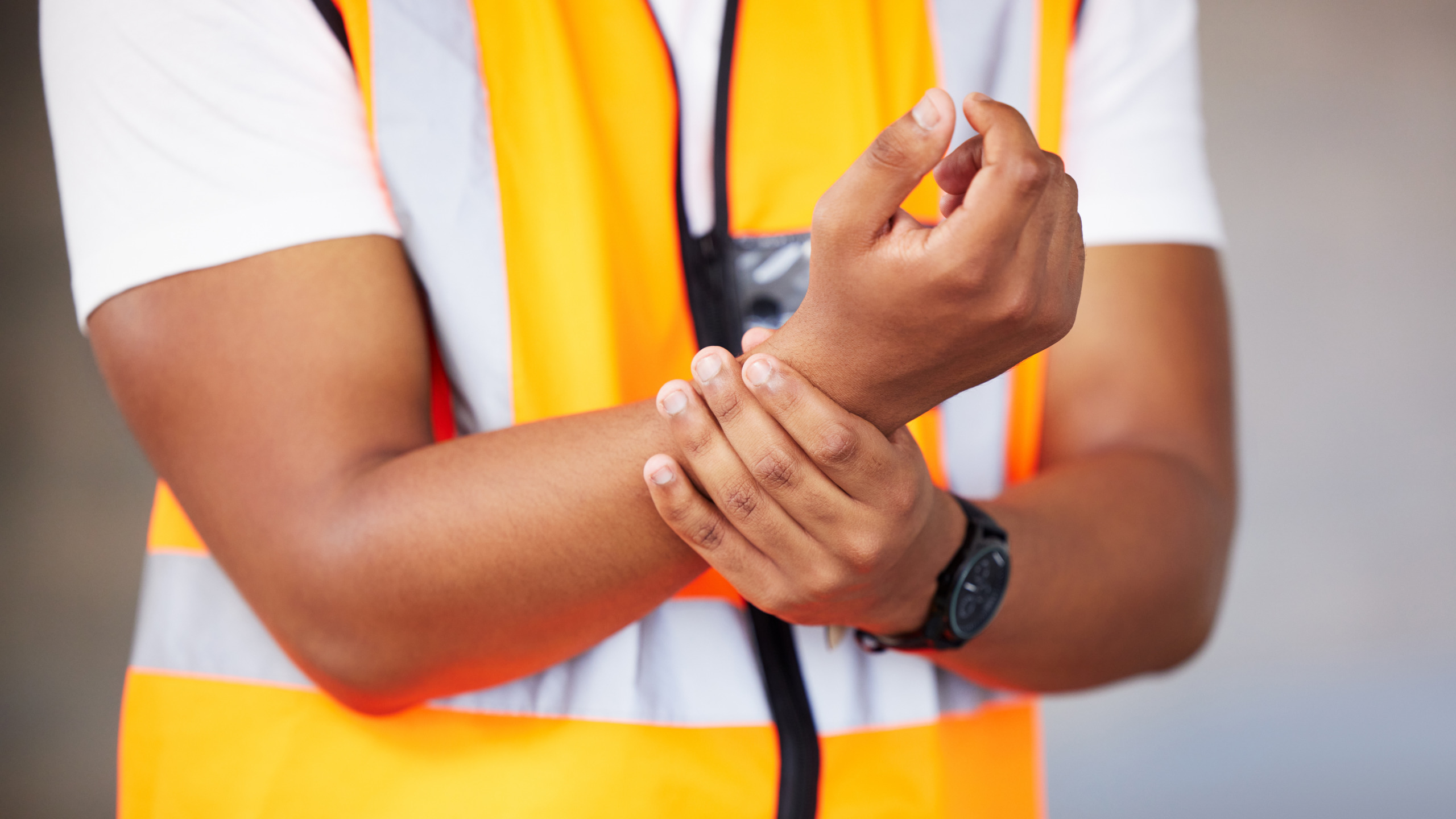 Construction worker holding his lower back in pain on a job site